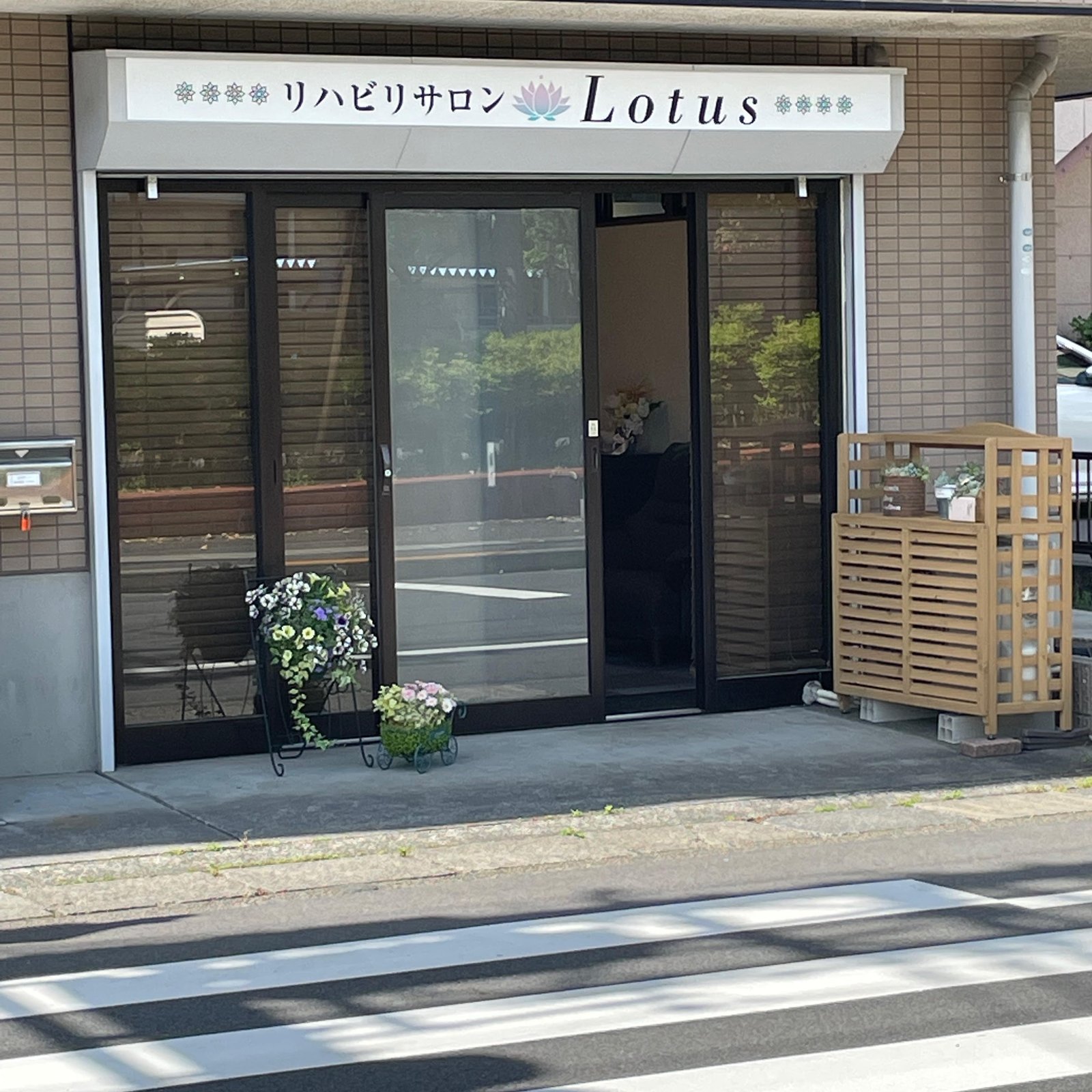 リハビリサロン Lotusの清潔感溢れる明るい店舗外観と入り口